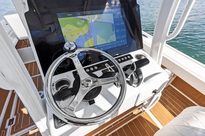Slide: The Image of 2021 Barker Boatworks 26 Open helm with navigation display and steering wheel. - 28