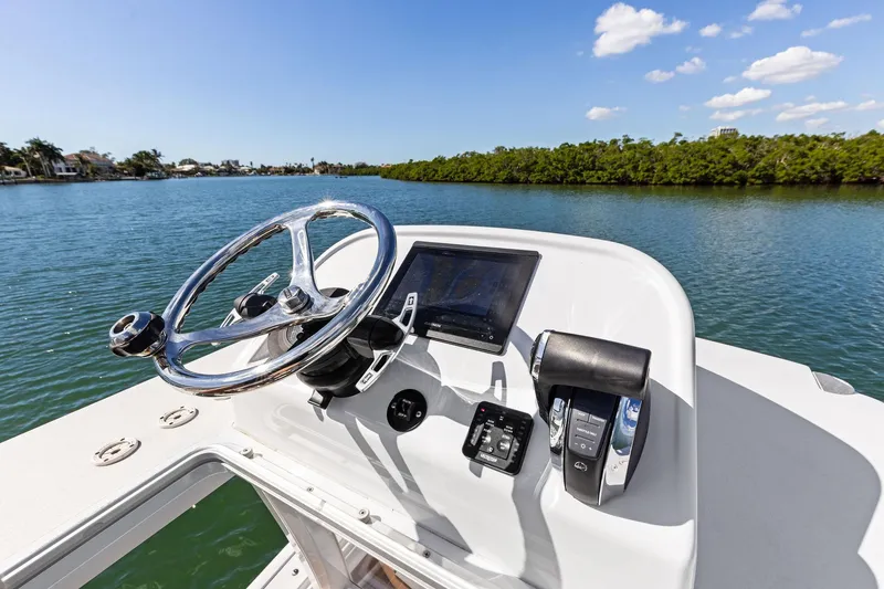 Slide: The Image of 2021 Barker Boatworks 26 Open helm with steering wheel and controls on a sunny day. - 33