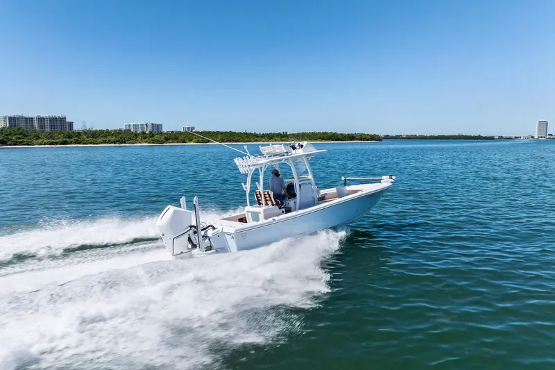 Slide: The Image of 2021 Barker Boatworks 26 Open cruising on clear blue water near coastline. - 44
