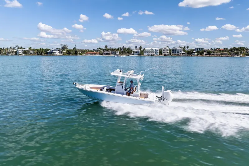 Slide: The Image of 2021 Barker Boatworks 26 Open cruising on a sunny day, with coastal homes in the background. - 45