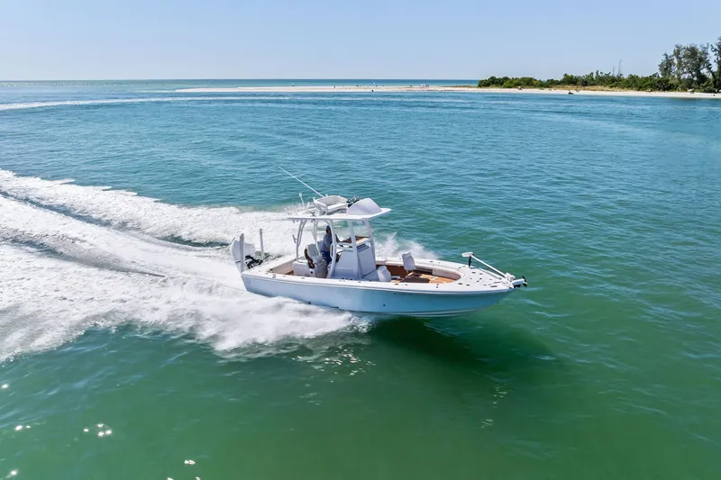 Slide: The Image of 2021 Barker Boatworks 26 Open cruising on clear blue water near a sandy shoreline. - 49