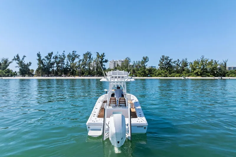Slide: The Image of 2021 Barker Boatworks 26 Open on calm water, with scenic shoreline backdrop. - 9