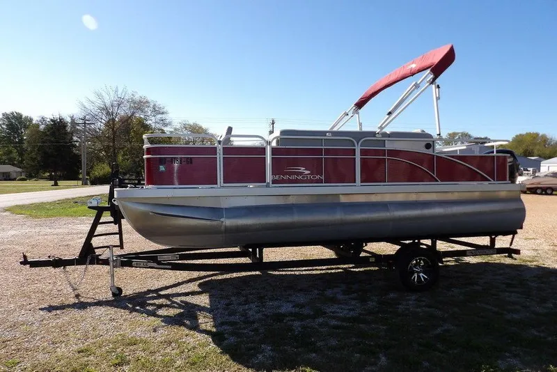 Slide: The Image of 2022 Bennington 20 SVF pontoon boat on trailer, red and silver design, sunny day. - 4