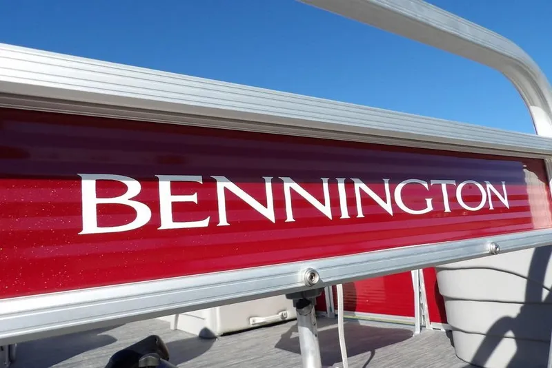 Slide: The Image of 2022 Bennington 20 SVF boat with red detailing and clear blue sky background. - 45