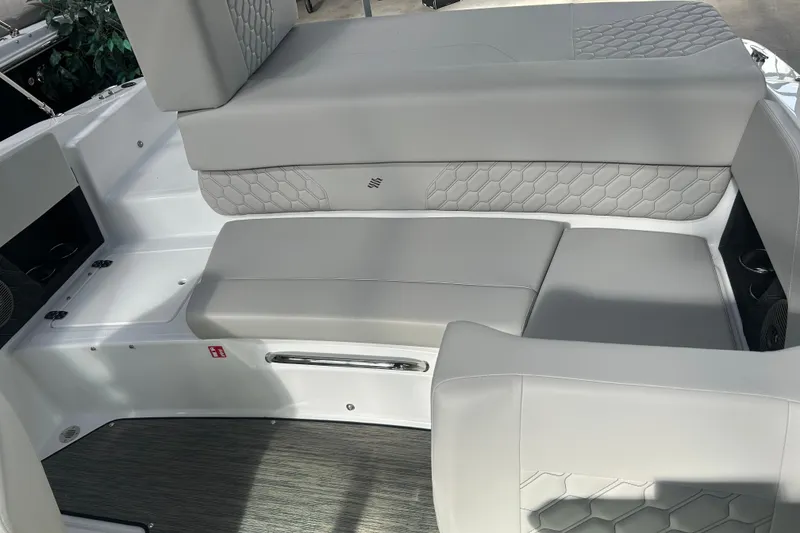 Slide: The Image of 2026 Four Winns H1 Freedom boat interior with gray cushioned seating and hexagonal pattern. - 12