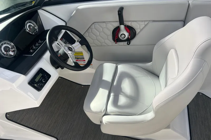 Slide: The Image of 2026 Four Winns H1 Freedom boat interior with steering wheel and white captain's chair. - 15