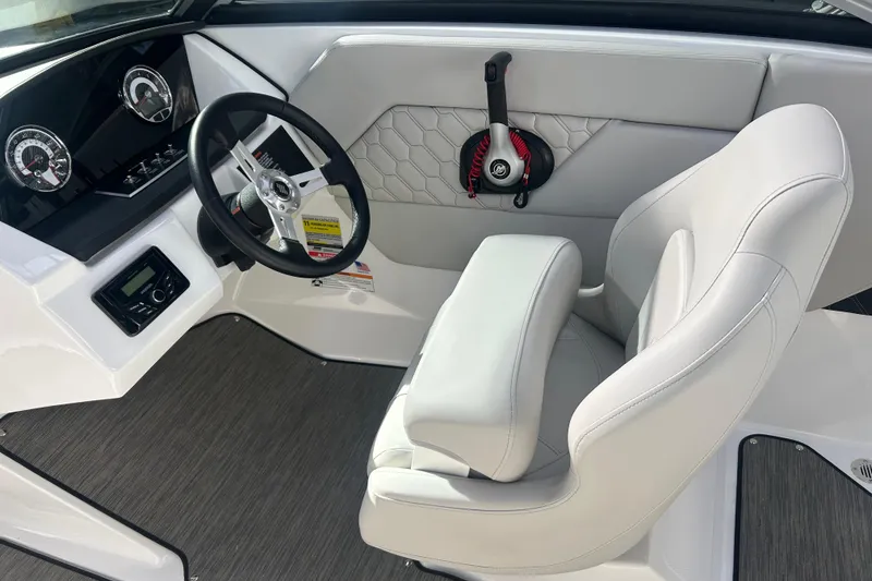 Slide: The Image of 2026 Four Winns H1 Freedom boat interior with steering wheel and white seating. - 16