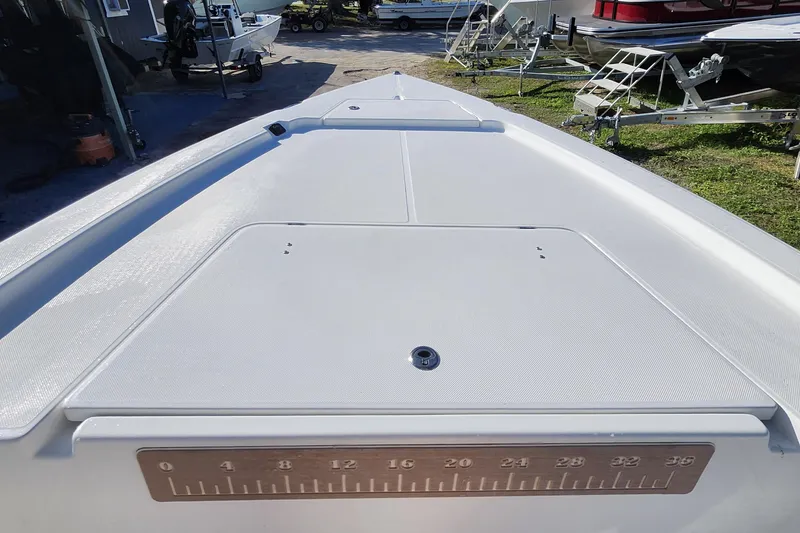 Slide: The Image of 2026 Savannah 220 IS boat deck with measurement scale, parked among trailers. - 13