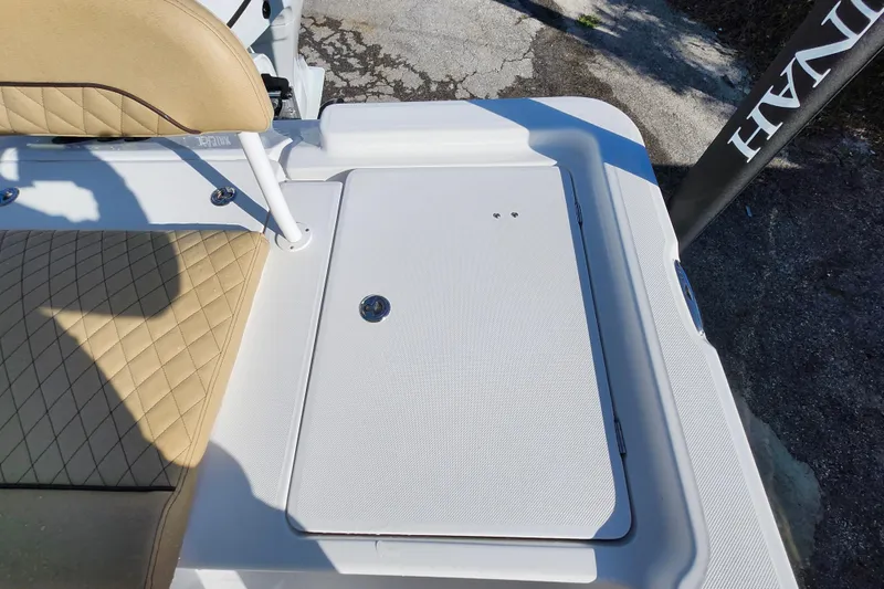 Slide: The Image of 2026 Savannah 220 IS boat deck with beige quilted seating and storage compartment. - 26