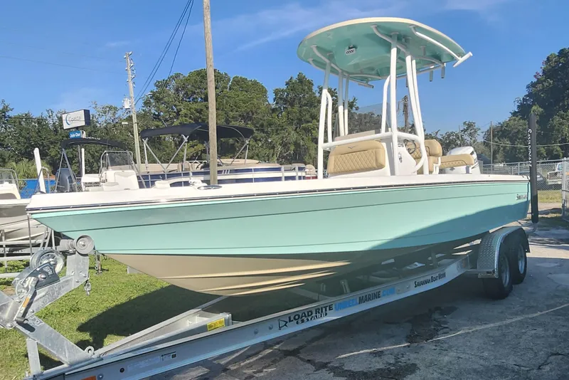Slide: The Image of 2026 Savannah 220 IS boat on trailer, light blue hull, parked outdoors. - 3