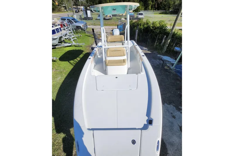 Slide: The Image of 2026 Savannah 220 IS boat with dual seats and canopy, parked outdoors. - 37