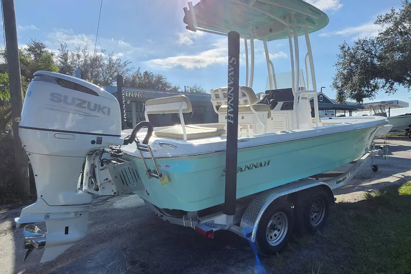 Slide: The Image of 2026 Savannah 220 IS boat with Suzuki engine on trailer, parked outdoors. - 5
