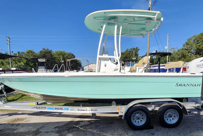 Slide: The Image of 2026 Savannah 220 IS boat on trailer, light blue hull, sunny day. - 7