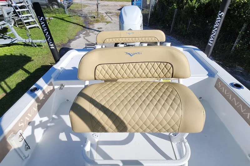 Slide: The Image of 2026 Savannah 220 IS boat with tan quilted seating, outdoor setting. - 8