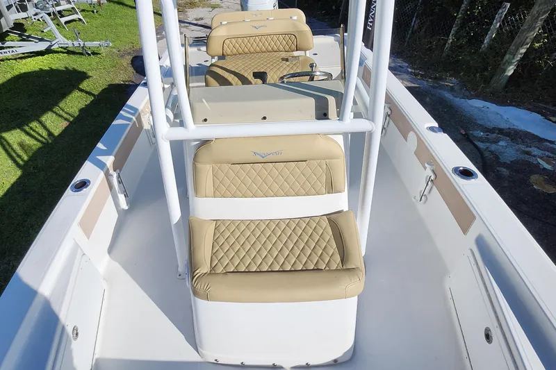 Slide: The Image of 2026 Savannah 220 IS boat interior with tan quilted seats and white framework. - 9