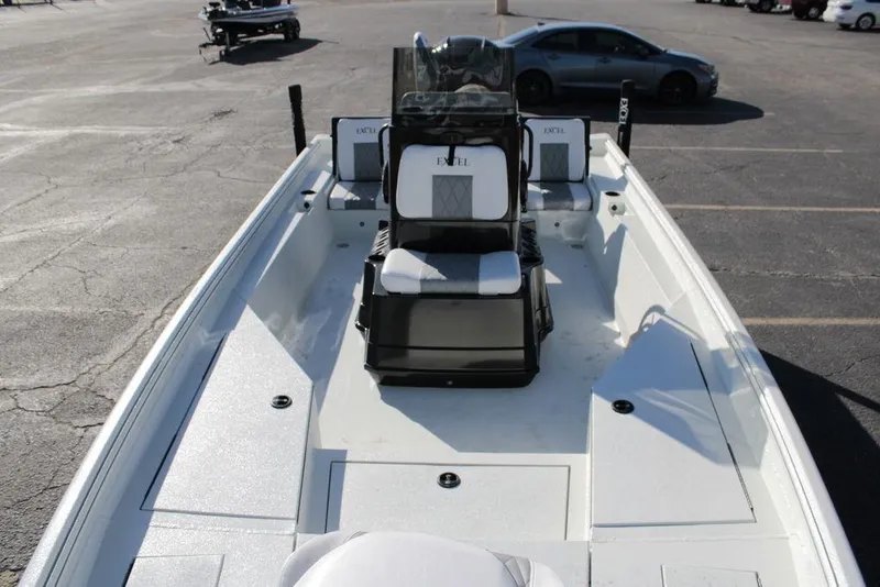 Slide: The Image of 2025 Excel Bay Pro Elite 230 boat interior with seating and console, parked in a lot. - 10