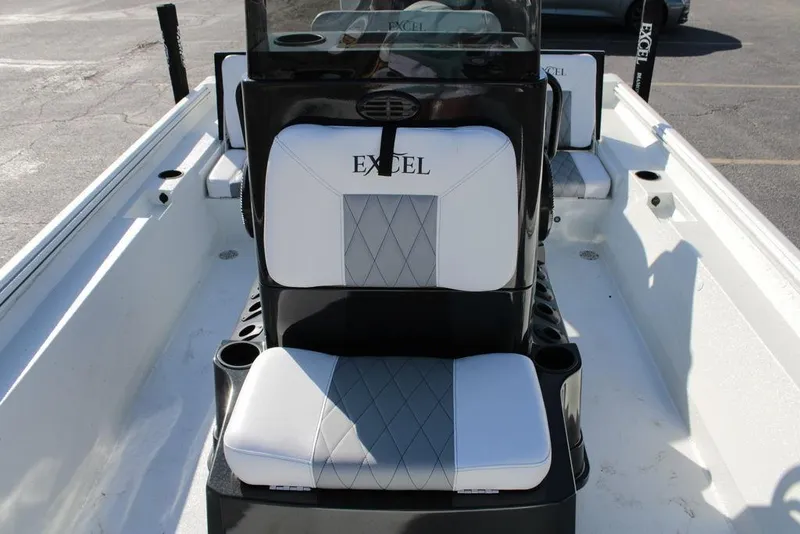 Slide: The Image of 2025 Excel Bay Pro Elite 230 boat interior with cushioned seating and console. - 11