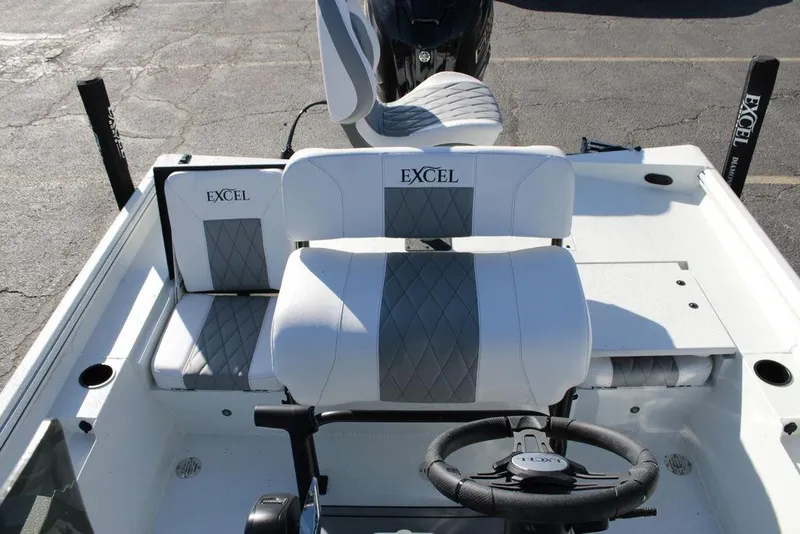 Slide: The Image of 2025 Excel Bay Pro Elite 230 boat interior with cushioned seating and steering wheel. - 16