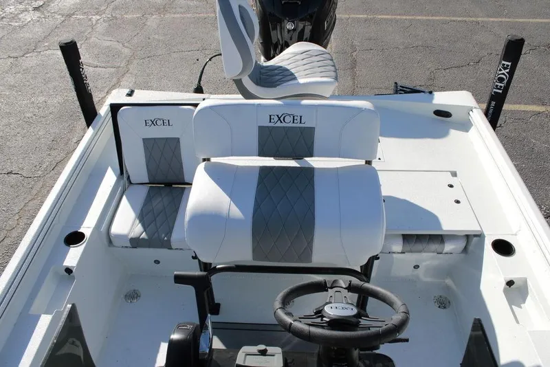 Slide: The Image of 2025 Excel Bay Pro Elite 230 boat interior with cushioned seating and steering wheel. - 19