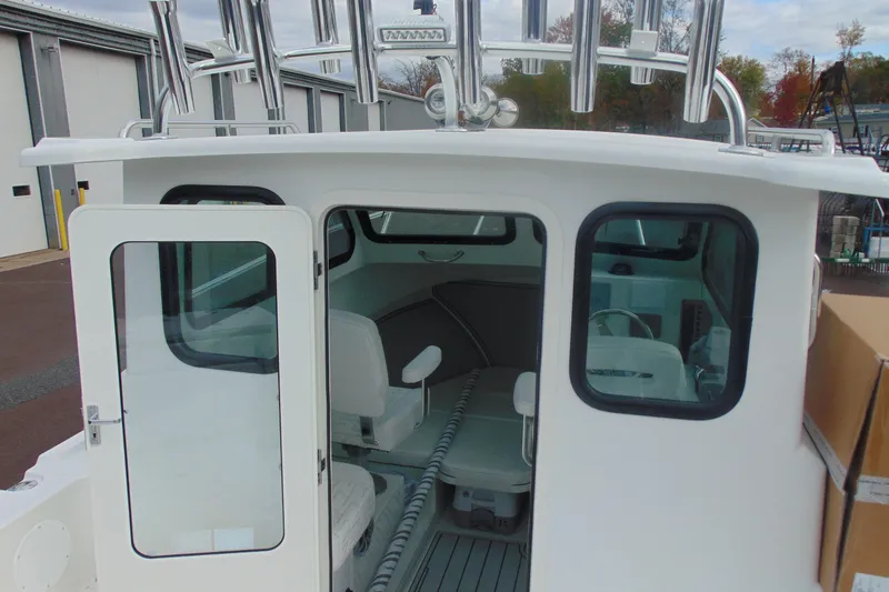 Slide: The Image of 2026 Parker 247 Explorer boat interior with seating and windows, docked outdoors. - 15