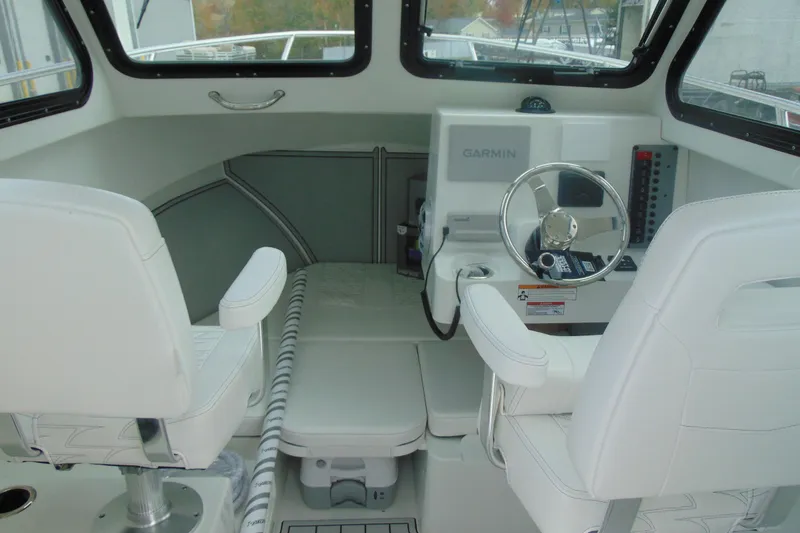 Slide: The Image of Interior of 2026 Parker 247 Explorer boat with Garmin navigation system and white seating. - 16