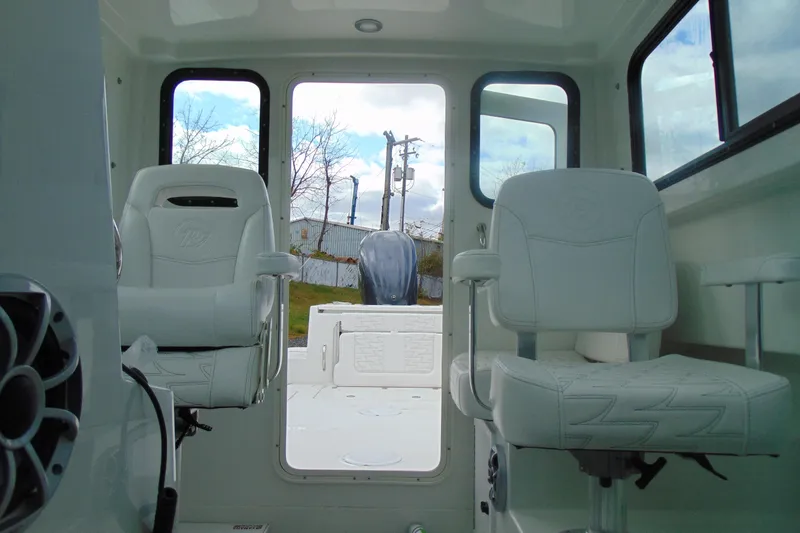 Slide: The Image of Interior of 2026 Parker 247 Explorer boat with white seating and open rear view. - 25