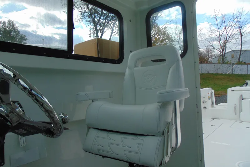 Slide: The Image of Interior of 2026 Parker 247 Explorer boat with white captain's chair and steering wheel. - 26