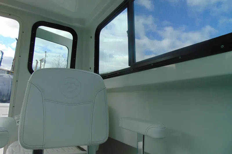 Slide: The Image of Interior of 2026 Parker 247 Explorer boat with white seating and large windows. - 27