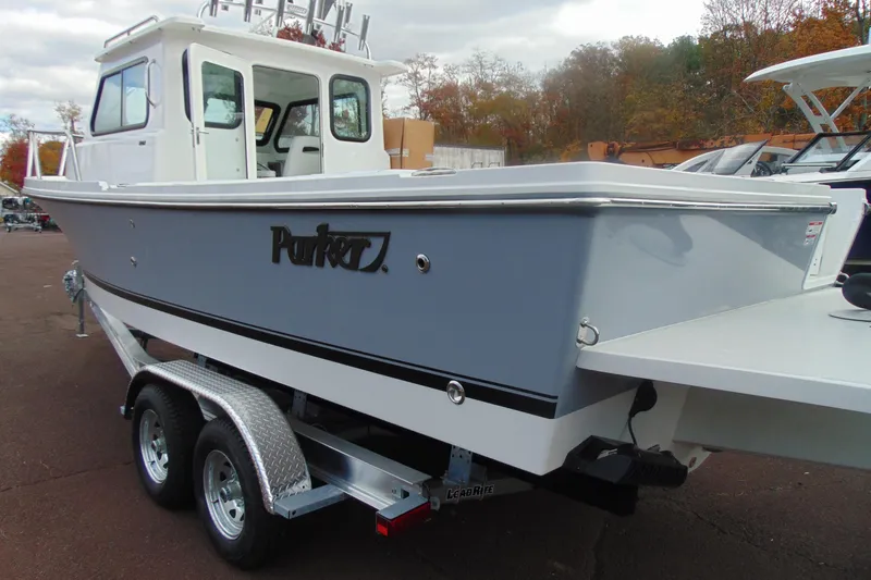 Slide: The Image of 2026 Parker 247 Explorer boat on trailer, gray and white design, parked outdoors. - 3