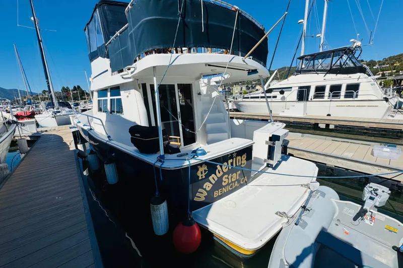 Slide: The Image of 2000 Mainship 390 Trawler docked at marina, featuring "Wandering Star" signage. - 10