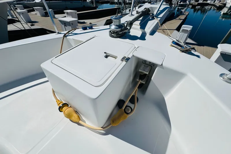 Slide: The Image of 2000 Mainship 390 Trawler deck with storage compartment and docked boats in background. - 18