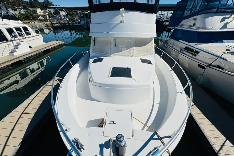 Slide: The Image of 2000 Mainship 390 Trawler docked at marina, showcasing spacious deck and sleek design. - 22