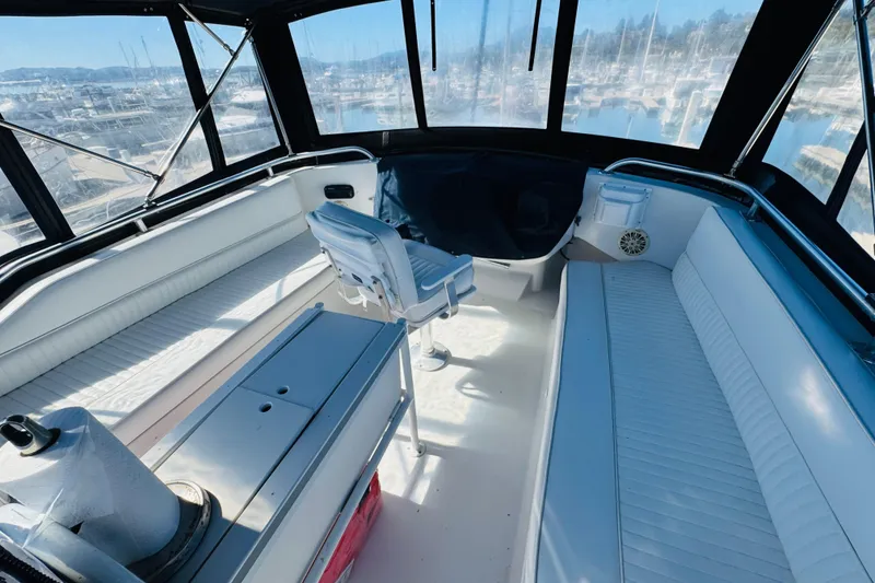Slide: The Image of 2000 Mainship 390 Trawler interior with white seating and panoramic windows. - 29
