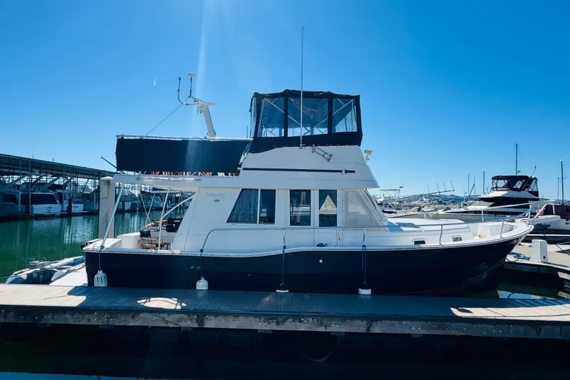 Slide: The Image of 2000 Mainship 390 Trawler docked at marina under clear blue sky. - 3