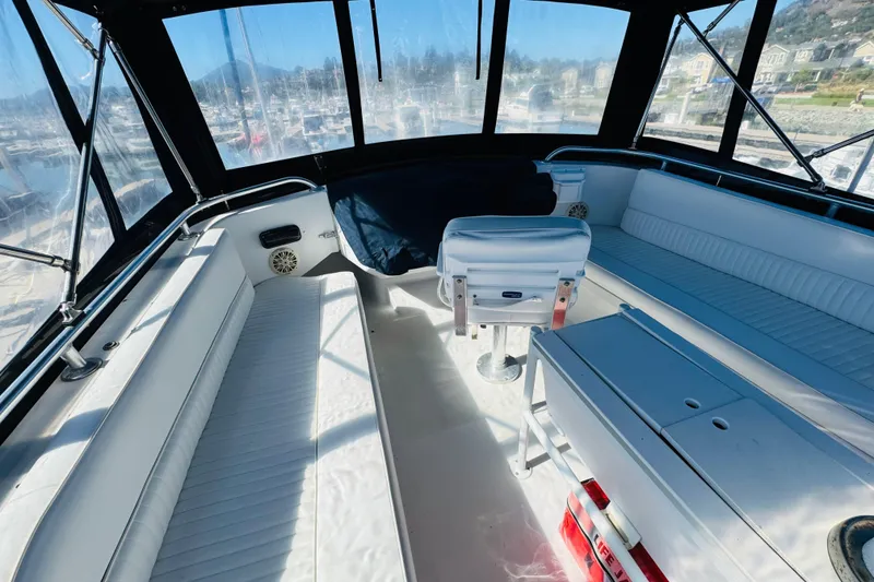 Slide: The Image of Interior of 2000 Mainship 390 Trawler with white seating and panoramic windows. - 30