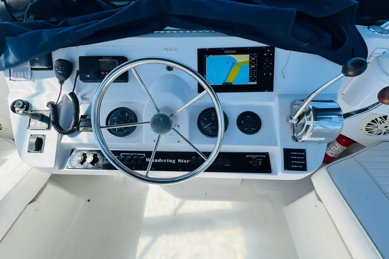 Slide: The Image of Control panel of a 2000 Mainship 390 Trawler with steering wheel and navigation equipment. - 32