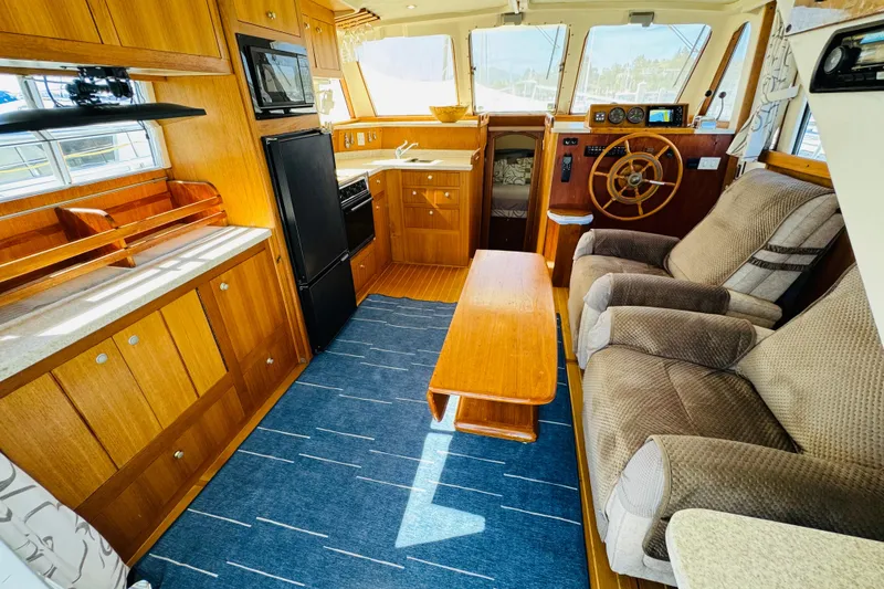 Slide: The Image of Interior of 2000 Mainship 390 Trawler with cozy seating and wooden cabinetry. - 42