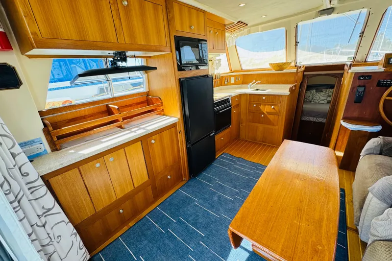 Slide: The Image of Interior of 2000 Mainship 390 Trawler with wooden cabinetry and modern kitchen amenities. - 43