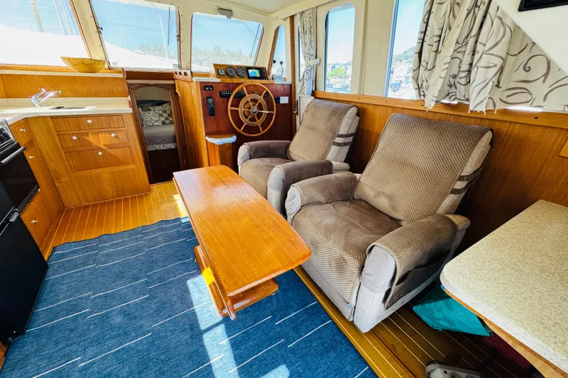 Slide: The Image of Cozy interior of 2000 Mainship 390 Trawler with plush seating and wooden accents. - 44