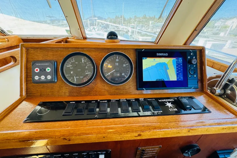 Slide: The Image of Control panel of a 2000 Mainship 390 Trawler with navigation and monitoring instruments. - 58