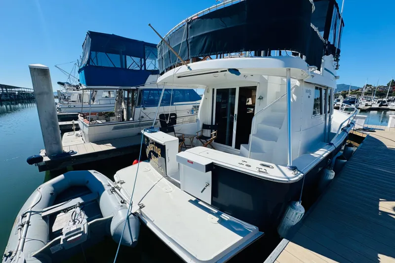 Slide: The Image of 2000 Mainship 390 Trawler docked at marina with inflatable dinghy. - 6