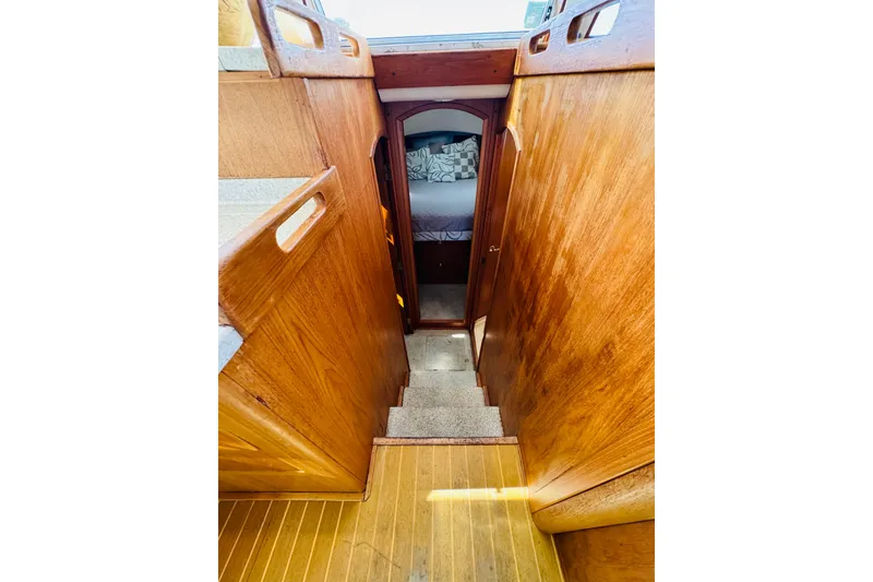 Slide: The Image of Interior view of 2000 Mainship 390 Trawler, featuring wooden stairs and cozy cabin entrance. - 62