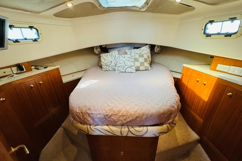 Slide: The Image of Cozy cabin interior of 2000 Mainship 390 Trawler with bed and wooden cabinetry. - 63