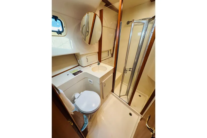 Slide: The Image of 2000 Mainship 390 Trawler bathroom with shower, sink, and toilet. - 69