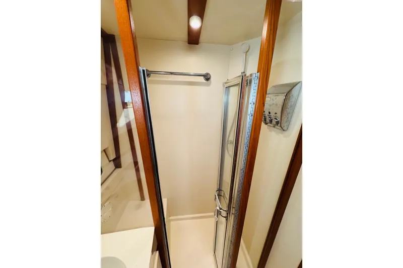 Slide: The Image of Shower area in 2000 Mainship 390 Trawler, featuring wooden trim and compact design. - 70