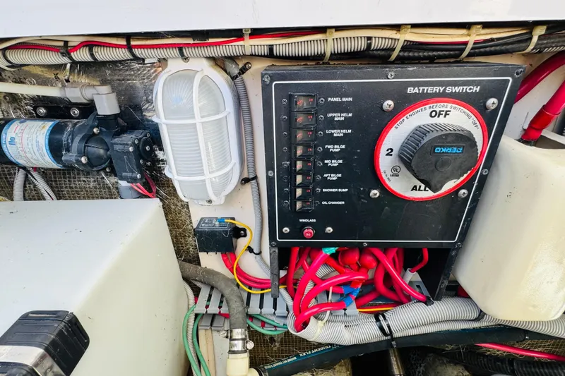 Slide: The Image of Battery switch panel on a 2000 Mainship 390 Trawler, featuring wiring and controls. - 76