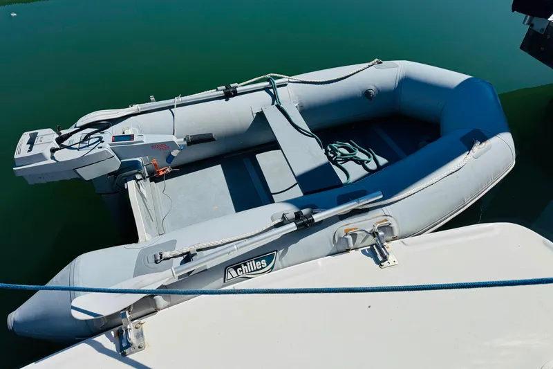 Slide: The Image of Inflatable dinghy attached to 2000 Mainship 390 Trawler, floating on calm water. - 78