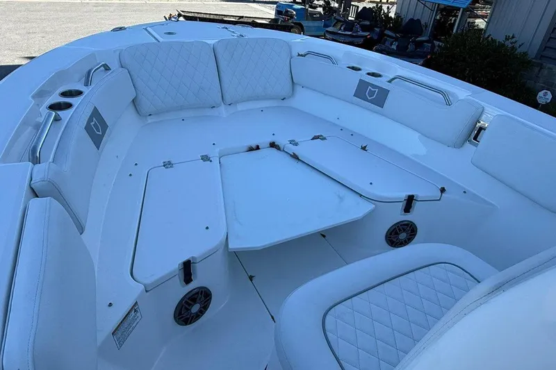Slide: The Image of 2026 Sea Fox 228 Commander boat interior with white cushioned seating and storage compartments. - 9