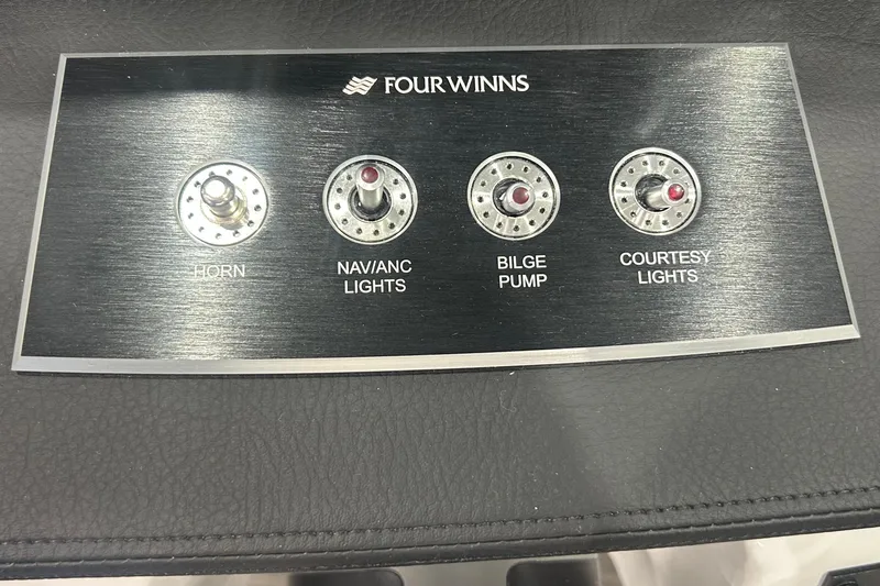Slide: The Image of Control panel of 2026 Four Winns H1 Freedom boat with switches for horn, lights, and bilge pump. - 19