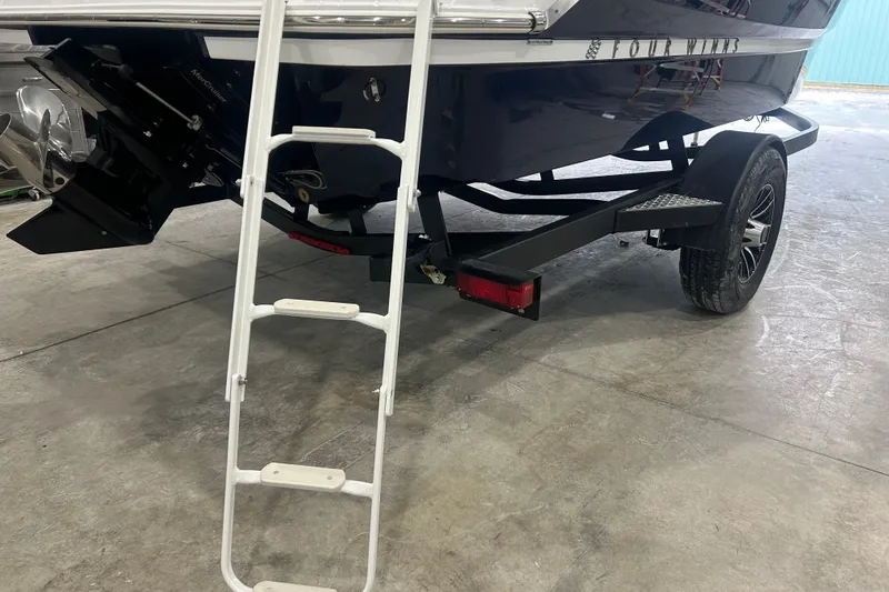 Slide: The Image of 2026 Four Winns H1 Freedom boat on trailer with ladder, rear view. - 8